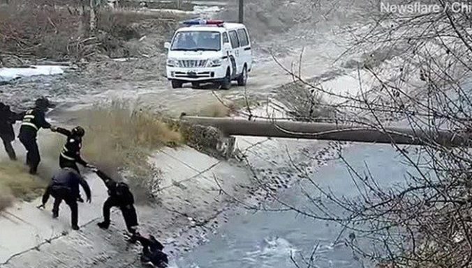 Policininkai išsirikiavo grandine, norėdami ištraukti vaiką iš sraunios upės (vaizdo įrašas)